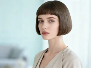 Elegancka 50-latka z nowoczesną, krótką fryzurą, prezentująca stylowe i pewne siebie cięcie w profesjonalnym salonie.
