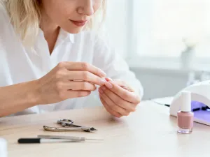 Stylowa kobieta z krótkim bobem o precyzyjnie wyciętym tyle, eksponującym linię szyi w nowoczesnym salonie fryzjerskim.