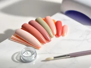 Paleta kolorów fryzjerskich z odcieniami popielatego brązu na marmurowym blacie, ilustrująca dobór pigmentów do neutralizacji rudości.