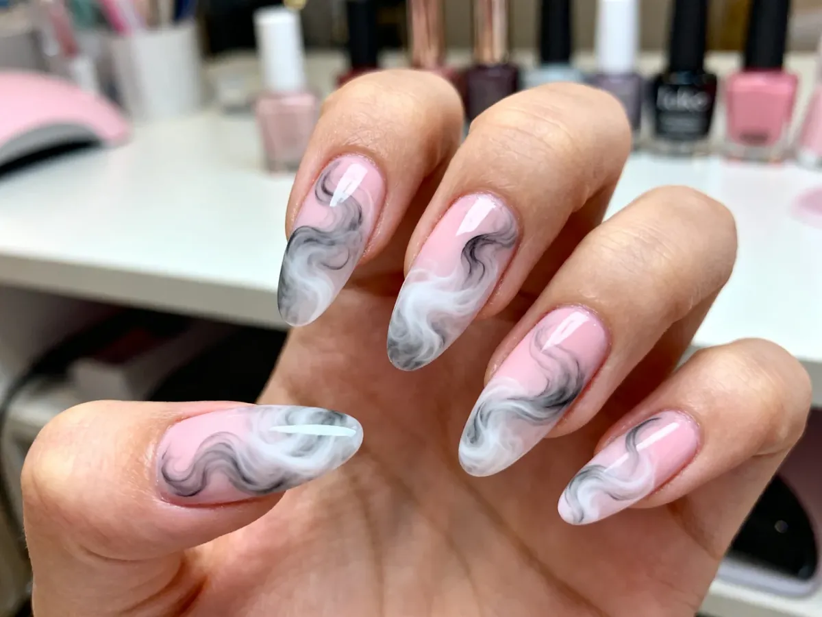 Manicure z efektem dymu w pastelowych kolorach na paznokciach o migdałowym kształcie.